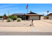Charming single-story home featuring solar panels, desert landscaping, and a two-car garage at 3848 W Kings Ave, Phoenix, AZ 85053