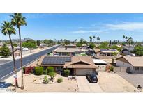 Charming single-Gathering home with a well-manicured desert front yard, solar panels, and a paved driveway at 3848 W Kings Ave, Phoenix, AZ 85053