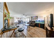 Gathering room with tile floors, comfortable reclining sofa, aquarium, ceiling fan, and bar seating at 3848 W Kings Ave, Phoenix, AZ 85053
