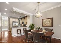 Staged dining area with wood table, elegant chandelier, and view into the beautifully appointed kitchen at 4401 N 24Th Pl, Phoenix, AZ 85016