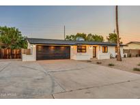 Contemporary home featuring a black garage door, modern lighting, and drought-resistant landscaping at 4910 E Shaw Butte Dr, Scottsdale, AZ 85254