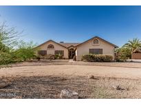 Tan single-story home showcasing desert landscaping, shrubbery, and a circular driveway at 6032 W Grovers Ave, Glendale, AZ 85308