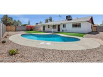Beautiful backyard featuring a sparkling in-ground pool and landscaped yard, perfect for outdoor entertaining at 8002 E Whitton Ave, Scottsdale, AZ 85251