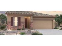 Charming single-story home featuring stone accents, a two-car garage, and low maintenance desert landscaping at 1365 S 215Th Ln, Buckeye, AZ 85326