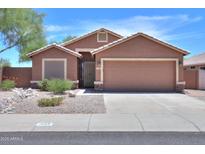 Charming single-story home featuring a low-maintenance desert landscape, tile roof and a two-car garage at 1563 E Peregrine Trl, Casa Grande, AZ 85122