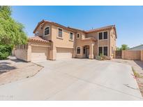 Beige two-story home featuring a spacious driveway and attached three-car garage at 15985 W Bartlett Ave, Goodyear, AZ 85338