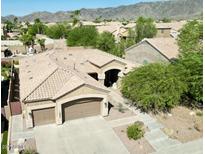 Aerial view of a home with a two-car garage, desert landscaping, and a beige tile roof nestled in a neighborhood at 16436 S 1St Ave, Phoenix, AZ 85045