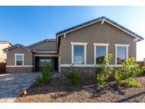 Charming single-Gathering home with gray stucco, stone accents, and neat landscaping, under a clear blue sky at 16455 W Avenida Del Sol --, Surprise, AZ 85387