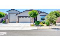 Charming single-story home with a well-manicured front yard and a three-car garage at 17003 W Alameda Rd, Surprise, AZ 85387