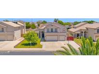 Charming two-story home features a well-manicured lawn, mature trees, and a spacious two-car garage at 1755 N 74 Th Pl, Mesa, AZ 85207