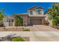 Charming two-story home featuring a neutral color palette, brick accents, and a paved driveway at 22682 E Indiana Ave, Queen Creek, AZ 85142