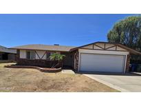 Charming single-story home with a two car garage and a well-maintained lawn at 2633 E Garnet Ave, Mesa, AZ 85204
