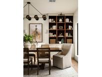 Elegant dining room features a dark wood table, stylish chairs, a modern chandelier, and built-in shelving at 3186 E Stella Ln, Phoenix, AZ 85016