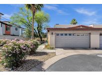 Home exterior featuring a garage with a gray door and desert landscaping at 3221 N 37Th St # 10, Phoenix, AZ 85018