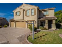 Charming two-story home featuring a three-car garage, desert landscaping and shuttered windows at 32311 N Cat Hills Ave, San Tan Valley, AZ 85144