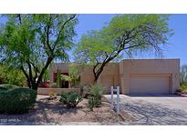 Southwestern home showcasing desert landscaping, mature trees, and a multi-car garage at 32516 N 68Th Pl, Scottsdale, AZ 85266