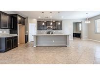 A kitchen showcasing an island, granite countertops, and dark wood cabinets at 4277 N 180Th Ln, Goodyear, AZ 85395
