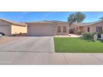 Charming single-story home featuring a two-car garage and well-maintained artificial lawn at 43935 W Sagebrush Trl, Maricopa, AZ 85138