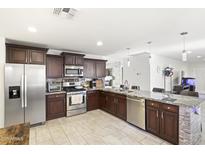 Well-equipped kitchen featuring stainless steel appliances, dark cabinets, and granite countertops at 43935 W Sagebrush Trl, Maricopa, AZ 85138