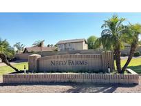 Welcoming community sign for Neely Farms with lush green landscape and palm trees on a clear day at 742 E Kyle Dr, Gilbert, AZ 85296
