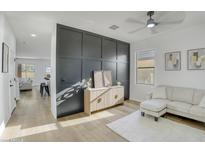 Stylish living room with a modern accent wall, ceiling fan and wood flooring at 8137 W Pueblo Ave, Phoenix, AZ 85043