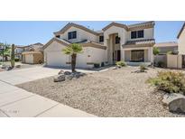 Inviting two-story home with neutral color palette, desert landscaping, and attached two-car garage at 1031 W Longhorn Dr, Chandler, AZ 85286