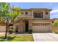 Two-story home featuring a stone entryway, well-maintained lawn, and a two-car garage at 1925 W Olive Way, Chandler, AZ 85248