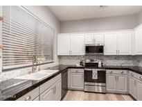 Bright kitchen featuring stainless appliances, white cabinets, and granite countertops at 1925 W Olive Way, Chandler, AZ 85248