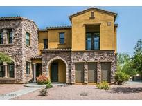 Attractive two-story townhouse with stone accents, an arched entryway, and a small balcony at 20750 N 87 St # 2103, Scottsdale, AZ 85255