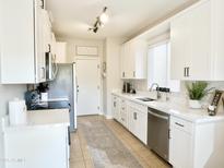 Bright kitchen featuring white cabinets, stainless steel appliances, and modern countertops at 34913 N 30Th Dr, Phoenix, AZ 85086