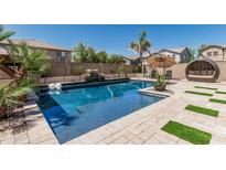 Resort-style pool with comfortable seating, waterfall features, and meticulous landscaping at 551 E Sun Valley Farms Ln, San Tan Valley, AZ 85140