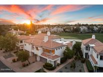 Beautiful townhouse with a red tile roof on a golf course, and a view of mountains at sunset at 7222 E Gainey Ranch Rd # 241, Scottsdale, AZ 85258