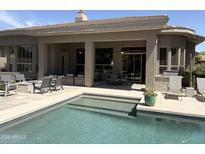 Inviting pool with built-in seating, covered patio, and outdoor entertaining space at 7940 E Quill Ln, Scottsdale, AZ 85255