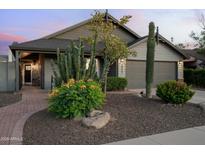 Charming home featuring desert landscaping with mature cacti, shrubs, and a manicured lawn, enhancing its curb appeal at 8037 E Krail St, Scottsdale, AZ 85250