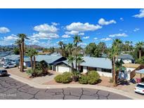 Charming single-Gathering home with palm trees and a well-maintained front yard under a blue sky at 8326 E Valley View Rd, Scottsdale, AZ 85250