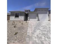 Charming single-Gathering home featuring a three-car garage, stone accents, and a well-manicured front yard at 18676 E Helian Dr, Gold Canyon, AZ 85118