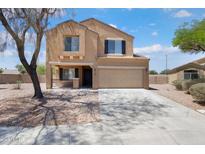 Two-story tan home featuring a two-car garage, a covered porch, and manicured landscaping at 23772 W Grove St, Buckeye, AZ 85326