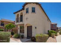 Two-story home featuring a private balcony and stucco exterior with a dark-stained front door at 2947 N Sonoran Hls, Mesa, AZ 85207