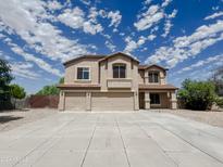 Inviting two-story home featuring a spacious driveway and a three-car garage against a vibrant blue sky at 3026 E San Manuel Rd, San Tan Valley, AZ 85143