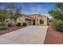 Charming home exterior features desert landscaping, mature trees, and a spacious driveway at dusk at 3467 N Hooper St, Buckeye, AZ 85396
