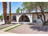 Stunning exterior features a welcoming arched entryway, mature landscaping, and a pristine white facade at 3646 W Brown St, Phoenix, AZ 85051