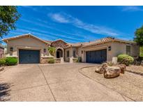 Charming single-story home with a desert landscape, a spacious driveway and a three-car garage at 3824 E Parkside Ln, Phoenix, AZ 85050