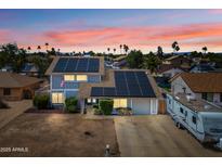 Charming two-story home with solar panels and well-maintained landscaping at sunset at 4136 W Hearn Rd, Phoenix, AZ 85053