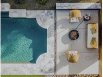 Aerial view of a modern pool with stone surround, two chairs and a lounger, and a fire pit seating area at 5541 E Cheery Lynn Rd, Phoenix, AZ 85018