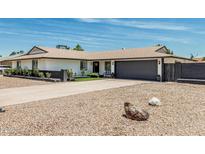 Charming home with a dark gray garage door, rock landscaping, and curb appeal at 11215 N 38Th N Ave, Phoenix, AZ 85029
