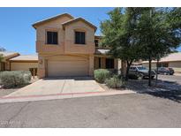 Two-story home featuring a two-car garage and low maintenance desert landscaping in front at 125 N 22 Pl # 14, Mesa, AZ 85213
