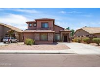 Charming two-story home with a well-maintained front yard and covered porch entryway at 13709 W Rovey Ave, Litchfield Park, AZ 85340