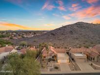 Stunning aerial view of a desert home with a mountain backdrop and vibrant sunset skies, and tile roof at 15232 S 36Th Pl, Phoenix, AZ 85044