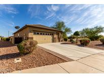 Charming home featuring a well-manicured front yard and a spacious two-car garage with a blue sky backdrop at 22417 W Loma Linda Blvd, Buckeye, AZ 85326