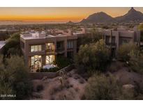 Beautiful Scottsdale home boasts desert landscape, luxurious exterior, and a picturesque mountain view at sunset at 25555 N Windy Walk Dr # 34, Scottsdale, AZ 85255